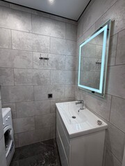 Modern bathroom with LED mirror and minimalist sink cabinet