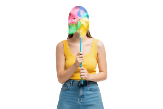 Playful young woman with her face obscured by a colorful spinning pinwheel.