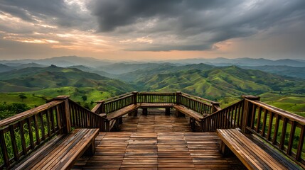 Fototapeta premium Wooden observation deck overlooking a vast valley of rolling hills.
