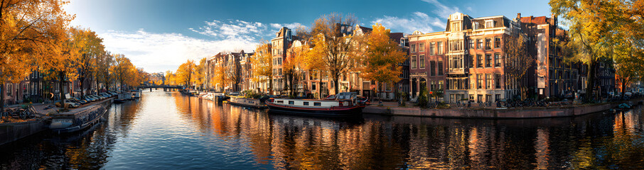 Fototapeta premium Panoramic autumn view of Amsterdam city. Famous Dutch channels and great cityscape. Colorful morning scene of Netherlands, Europe. Traveling concept background.