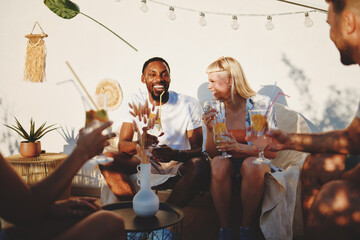 Friends are having refreshing drinks and enjoying conversation on a rooftop terrace during a summer sunset party