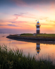 Sonnenuntergang an einem kleinen Leuchtturm an der deutschen Nordseek&uuml;ste.