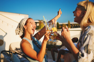 Friends enjoying drinks at sunset party on rooftop