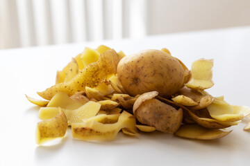 Potato peels crawling on a white napkin on the table.