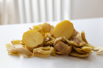 Potato peels crawling on a white napkin on the table.