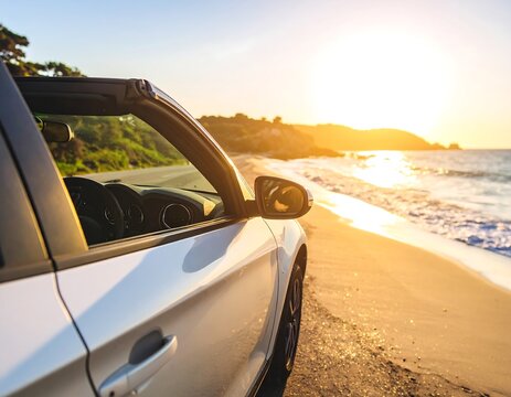 Convertible car on beach at sunset