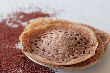 Ragi appams with crisp edges and soft centers served on a ceramic plate, made from fermented finger millet batter