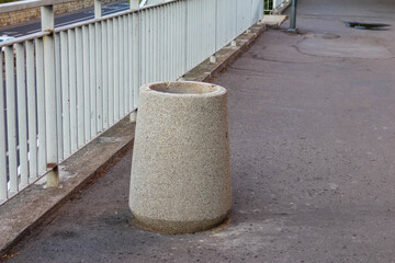 Large cylindrical concrete structure with rounded top positioned on paved surface creating...