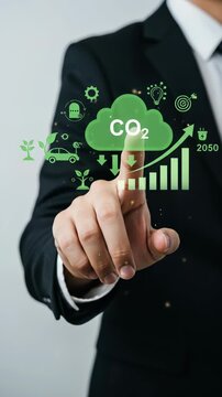 CO2 Reduction Goal 2050: Businessman touching the virtual screen with green eco icons, promoting sustainability and green technology towards net-zero future.
