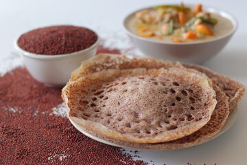 Ragi appams made from finger millet flour served with creamy vegetable stew, garnished with cashews and herbs