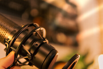 A close-up macro shot of a microphone’s shock mount in a warm-lit workspace, ideal for showcasing...