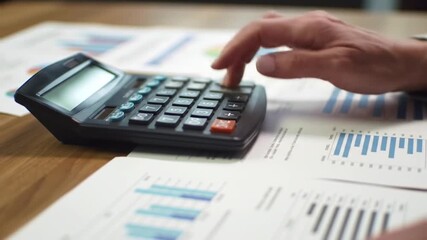 Hands on calculator with financial documents - Powered by Adobe