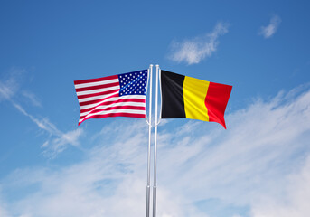 flags of  belgium and United States of America over blue sky background.