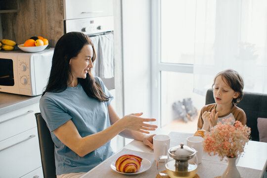 Mother and son sharing a pleasant breakfast at home - Powered by Adobe