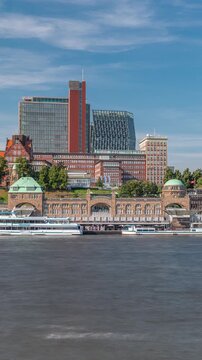 Skyline timelapse of St. Pauli Piers (Landungsbrucken) with ferries in Hamburg, Germany. Iconic clock tower, ships docked in the marina and panoramic views of the harbor under a cloudy blue sky