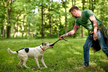 Playful interaction between a man and his dog in a forest