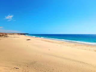 Landscape of fine sand on the beach at low tide in Fuerteventura. Coastal landscapes and wild nature. Paradise lagoon background.