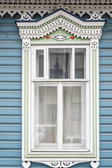 Fragment of the facade of a wooden russian house of the 19th century with carved decor based on...