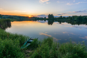 sunset on the lake with fishing boat 