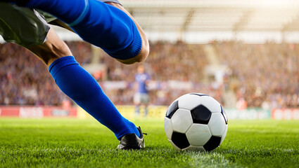 Obraz premium Athlete Prepares To Kick Soccer Ball During Match on Green Grassy Field with Blurred Stadium Crowd in Background