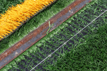 Synthetic turf field under construction with lines and graphics being installed.	