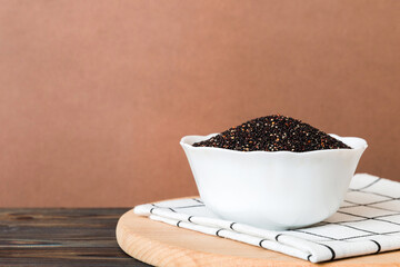 quinoa seeds in bowl on colored background. Healthy kinwa in small bowl. Healthy superfood