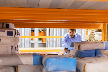 Warehouse worker scan goods in inventory in a hardware store and check stock product on digital tablet