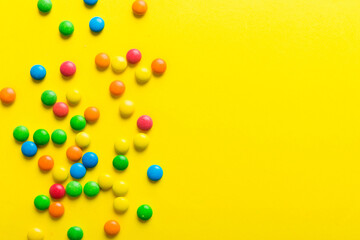 Mixed collection of colorful candy, on colored background. Flat lay, top view. frame of colorful chocolate coated candy