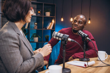 Podcasters discussing animated topics, wearing headphones, speaking into microphones inside...
