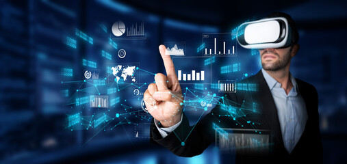 A businessman in virtual reality engages with data analytics in a high-tech environment, focusing...