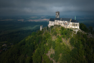 Gothic Bezděz Castle rises above a mist-covered forested hill in morning light. Ideal for: Czech heritage promotion, medieval history visuals, and travel storytelling.