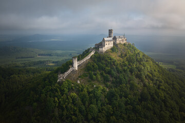 Gothic Bezděz Castle rises above a mist-covered forested hill in morning light. Ideal for: Czech heritage promotion, medieval history visuals, and travel storytelling.