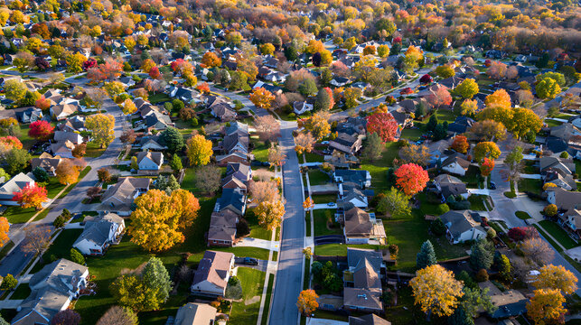 Aerial drone view of American suburban neighborhood. Establishing shot of America's suburb. Residential single family houses pattern. Autumn Fall season