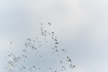 Splashes and jets of water against light background.