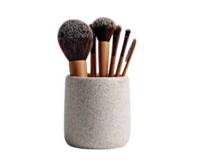 Photo of a set of professional makeup brushes neatly arranged in a speckled ceramic holder, isolated on a transparent background for beauty enthusiasts