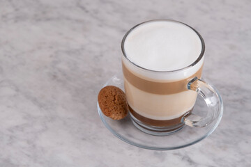 Creamy cafe latte in a stylish cup. Top view. Freshly brewed cafe latte with smooth foam. Hot latte coffee. Minimalist norning moment. Warm cafe latte with frothy milk. Barista style
