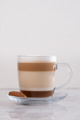 Creamy cafe latte in a stylish cup. Top view. Freshly brewed cafe latte with smooth foam. Hot latte coffee. Minimalist norning moment. Warm cafe latte with frothy milk. Barista style