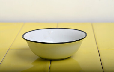 Beautiful photo of a Vintage Enamel Mock up Bowl on Yellow Tiled Surface