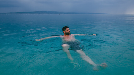 Man swimming in turquoise Adriatic Sea in Croatia