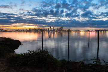 Sunrise Over The Seattle Skyline Across Elliott Bay. A calm early morning sunrise in the Pacific...
