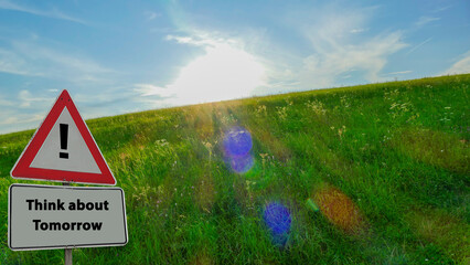 Sign Think about Tomorrow Sun behind green Pasture
