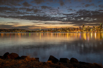 Sunrise Over The Seattle Skyline Across Elliott Bay. A calm early morning sunrise in the Pacific Northwest with beautiful clouds adding to the atmosphere.