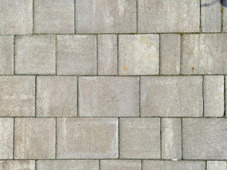 Close-up view of textured concrete paving stones, forming a durable surface for walkways or driveways. Ideal for construction, landscaping, and urban design projects.