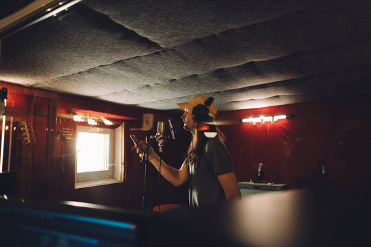 Singer recording song in professional studio using smartphone lyrics - Powered by Adobe