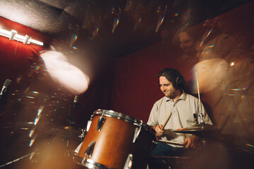 Musician playing drums in recording studio with motion blur effect