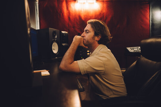 Sound engineer working in recording studio mixing music - Powered by Adobe