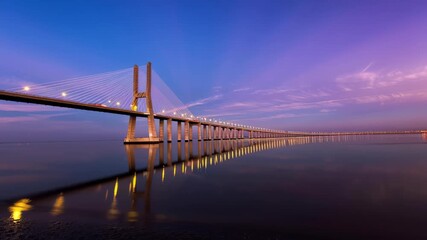 Portugal, Lisbon - Vasco da Gama bridge in Lisbon at sunset.  bridge reflecting in tranquil water at golden hour, ideal for infrastructure, transportation and civil engineering design. Time-lapse, 4K  - Powered by Adobe