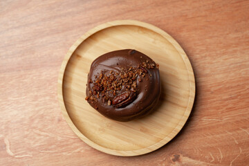 Delicious chocolate dessert with crunchy topping served on a wooden plate