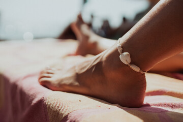 Close up image of female feet and legs at beach, summer and holiday concept
