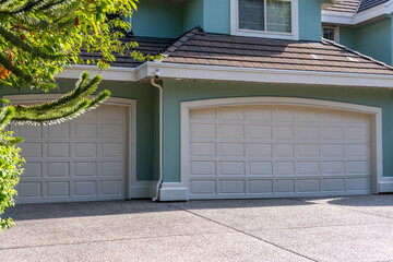 Garage door in luxury house with trees and nice landscape in Summer in Vancouver, Canada, North America. Day time on July 2025.